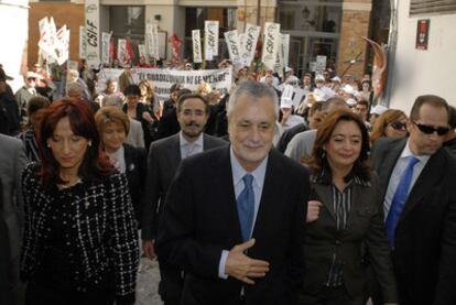 Peñalver, Griñán y Moreno se dirigen a una inauguración en Jaén tras pasar junto a un grupo de manifestantes.