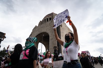 Una mujer alza un cartel al comienzo de la marcha, frente al Monumento a la Revolución, en la capital del país.