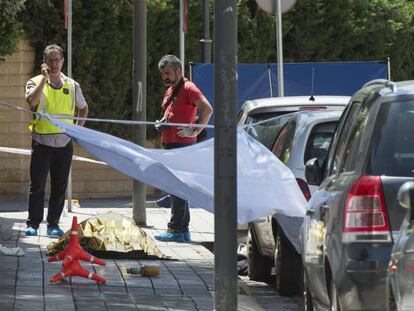 Dos 'mossos', junto al cadáver de un hombre asesinado en el centro de Lleida, en junio.