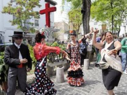 Vecinos del barrio granadino del Albaicín bailan delante de la cruz que obtuvo el primer premio en la modalidad de plazas por la festividad de las Cruces de Mayo.