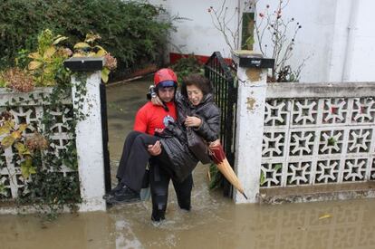 Un bombero lleva en brazos a una mujer para ayudarla a salir de su casa tras las inundaciones que en noviembre de 2011 asolaron los barrios donostiarras de Txomin y Martutene.