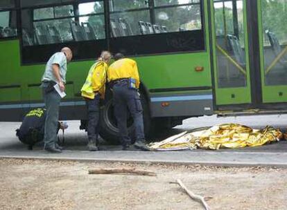 El cadáver de la septuagenaria yace cubierto junto al autobús que la atropelló.