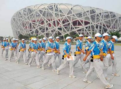 Voluntarios frente al Estadio Nacional de Pekín, conocido como <i>Nido de Pájaros.</i>