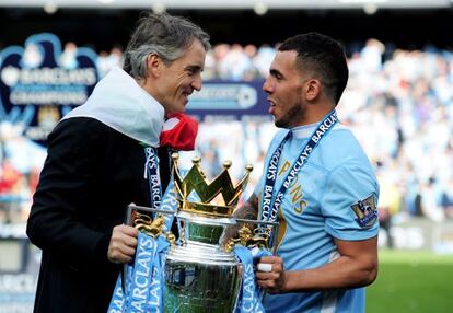 Mancini sostiene la copa de campeón con Carlos Tevez