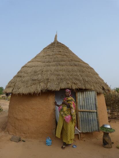 Una mujer invita a pasar a su cabaña en la región de Koddo, en Níger. En el interior hay una litera, una cama y ropa. Las demás tareas cotidianas se desarrollan en el exterior.