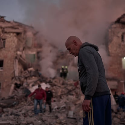 KYIV, UKRAINE - AUGUST 28: A person walks past as rescuers work at the site of a residential building hit by a Russian missile on August 28, 2025 in Kyiv, Ukraine. The strike struck between the third and fourth floors of a five-story house, according to Interior Minister Ihor Klymenko. At least four people were reported killed, with 20 injured, as emergency services continued operations. (Photo by Kostiantyn Liberov/Libkos/Getty Images)