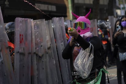 Una mujer lanza pintura sobre la policía que acompañó el recorrido.