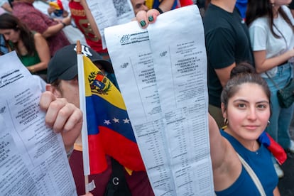 Una mujer muestra copias de las actas de resultados.