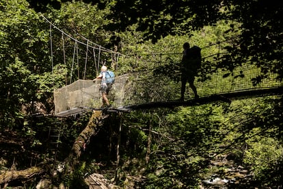 Dos senderista cruzan uno de los puentes colgantes que conforman la ruta de las Gorges de Carançà.