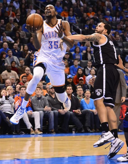 El jugador de los Nets Deron Williams intenta bloquear a Kevin Durant de los Thunders de Oklahoma