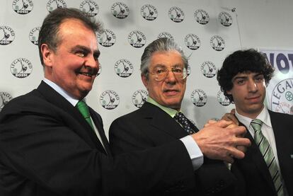 El líder de la Liga Norte, Umberto Bossi (centro), posa con su hijo y el ministro Roberto Calderoli, ayer en Milán.