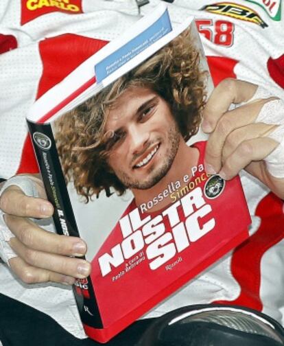 El piloto italiano Michelle Pirro ojea el libro sobre Simoncelli publicado recientemente.