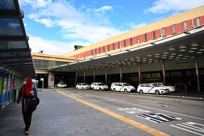 Una pasajera camina solitaria portando una mascarilla en el aeropuerto madrileño Adolfo Suárez Barajas. Imagen tomada el 16 de marzo.