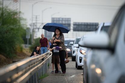 Una mujer y un niño se protegen tras el aviso de bombardeo, en una autopista de Tel Aviv, este lunes en Israel.