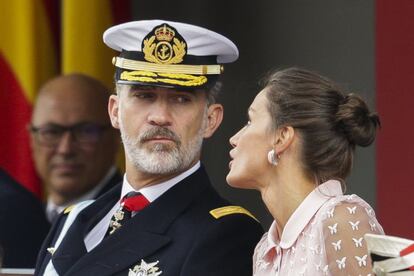 Los Reyes hablan durante el desfile. En la imagen se ven los pendientes de doña Letizia, que le prestó su suegra.