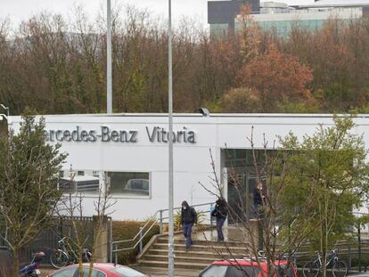 Dos trabajadores con mascarilla salen de la puerta sur de la fábrica de Mercedes-Benz en Vitoria.
