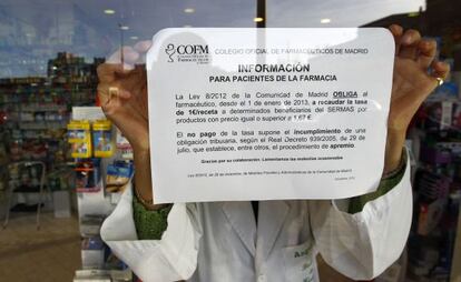 Cartel donde se explica el cobro de euro por receta en una farmacia de Madrid.