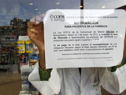 Cartel donde se explica el cobro de euro por receta en una farmacia de Madrid.