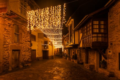 Una calle del pueblo medieval de Puebla de Sanabria, en Zamora, con la iluminación navideña por la noche.