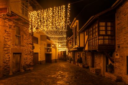 Una calle del pueblo medieval de Puebla de Sanabria, en Zamora, con la iluminación navideña por la noche.