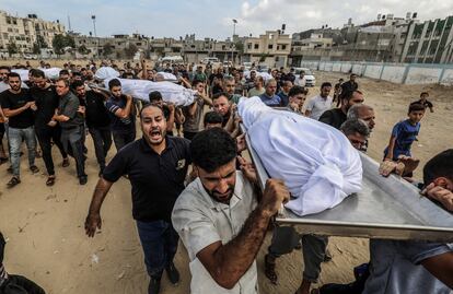 Hombres palestinos transportan cadáveres de las víctimas de un ataque aéreo israelí, este miércoles.