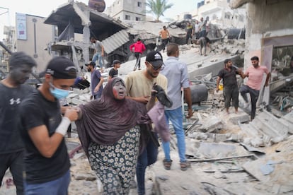 Una mujer es rescatada tras un bombardeo israelí en Deir el Balah, en la franja de Gaza, este domingo.