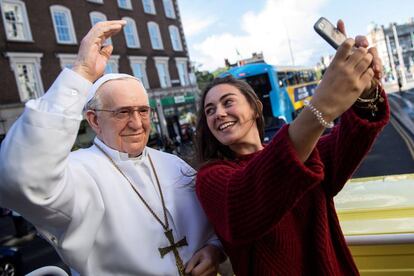 Una joven, junto a una estatua del papa Francisco este viernes en Dublín.