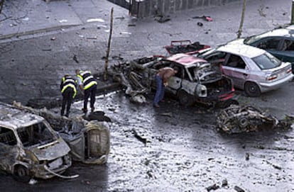 Agentes de policía inspeccionan los restos del coche bomba que explotó frente al estadio Bernabéu.