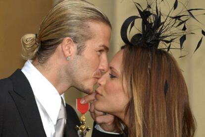 David Beckham besa a Victoria el día que recibió la Orden del Imperio Británico en noviembre de 2003.