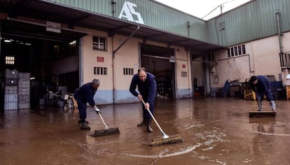 Trabajadores de una empresa de Muxika limpian el barro tras las inundaciones, el 12 de enero de 2018.