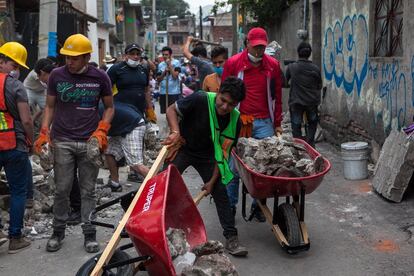 Voluntarios ayudan a retirar restos de los edificios en San Gregorio Atlapulco en Xochimilco, al sur de la Ciudad de México.