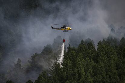 Un helicóptero realiza labores de extinción en una de las zonas afectadas. Avionetas, helicópteros e hidroaviones trabajaron intensivamente durante la mañana del martes