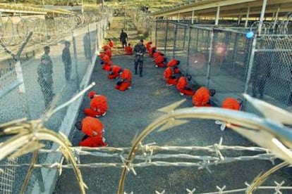Militares estadounidenses custodian a detenidos en la base de Guantánamo en 2002.