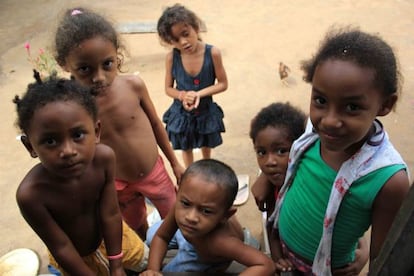 Un grupo de niños ocupan las escaleras de una casa para ver la televisión.