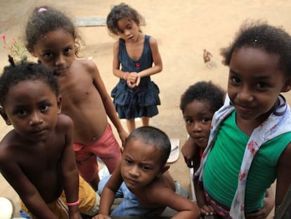 Un grupo de niños ocupan las escaleras de una casa para ver la televisión.