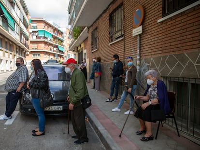 Un grupo de vecinos esperan su turno frente a la entrada del centro de salud Puerta Bonita, en Madrid.