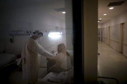 Un doctor atiende a una paciente infectada por coronavirus en el hospital Ezeiza, en Buenos Aires (Argentina). El país ha vuelto a registrar este jueves otro récord en sus nuevos casos de coronavirus, más de 6.000, mientras que los fallecidos a causa de la enfermedad avanzan hacia los 3.000.