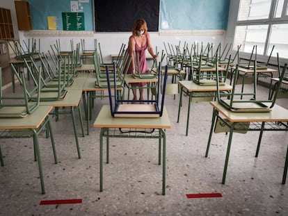Una profesora mide la distancia entre las mesas de un aula en la víspera del curso escolar