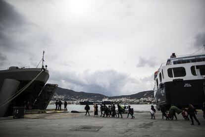 Un grupo de migrantes observa el exterior desde la entrada del buque griego atracado en el puerto de Mitelene, en Lesbos (Grecia), en el que el Gobierno les está alojando.