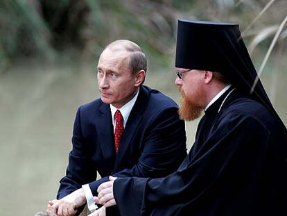 Vladímir Putin y un sacerdote ortodoxo, ayer junto al río Jordán.