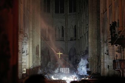 Interior de la catedral de Notre-Dame després de l'incendi. L'altar està envoltat de trossos de fusta carbonitzada i encara fumejant.