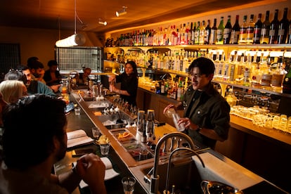 Dos mixólogos preparan cócteles frente a los comensales en la barra de Bar Mauro. 