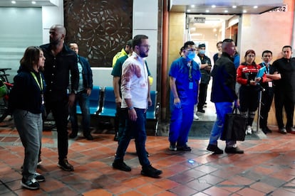 Andrés Barrios, concejal de Bogotá, camina fuera de la clínica Medicentro con la camisa ensangrentada, tras el atentado contra Uribe Turbay.