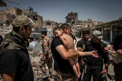 Un niño en brazos es evacuado de la última zona controlada por el Estado Islámico en la Ciudad Vieja de Mosul por un hombre sospechoso de ser militante, vigilado por soldados de las Fuerzas Especiales iraquíes, el 12 de julio de 2017. Fotografía nominada en la categoría 'Photo of the Year' del fotógrafo Ivor Prickett.