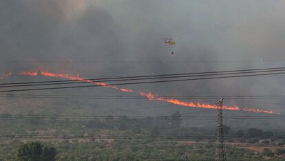 Un helicóptero trabaja en el incendio forestal declarado en una zona de barranco de Beneixama (Alicante), el 15 de julio de 2019. El fuego afectó a la superficie de masa forestal en una zona de difícil acceso conocida como la Solana.