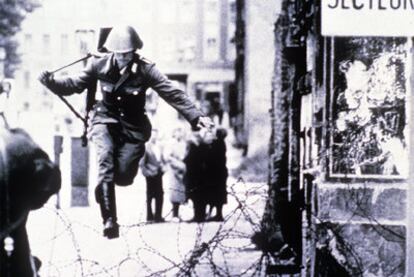 Un soldado huye de Alemania Oriental durante la construcción del Muro.