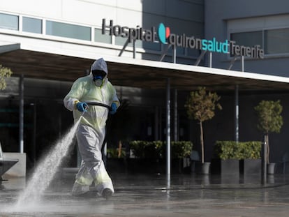 Un operario del servicio de limpieza en Santa Cruz de Tenerife desinfecta el exterior de un hospital de Quirónsalud.