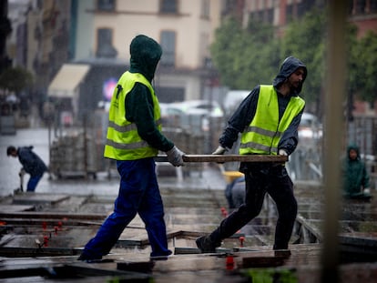 Un grupo de operarios durante el montaje de palcos de Semana Santa en Sevilla, este lunes.