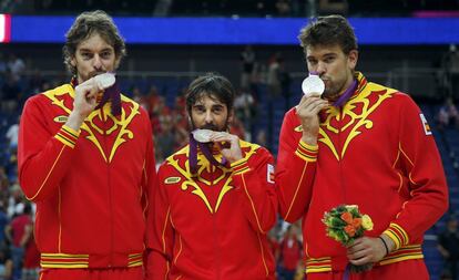 Marc Gasol, Juan Carlos Navarro y Pau Gasol ( de derecha a izquierda) , besan en el podio la medalla de plata conseguida después de que España resultara derrotada por Estados Unidos por 107- 100, en la final de la competición de baloncesto de los Juegos Olímpicos de Londres 2012.