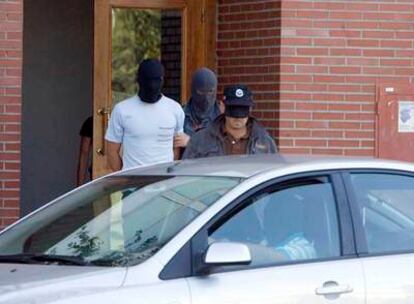 Joseba Mikel Otxoa (a la izquierda), detenido ayer en Vitoria, sale de su domicilio custodiado por dos <i>ertzainas</i>.